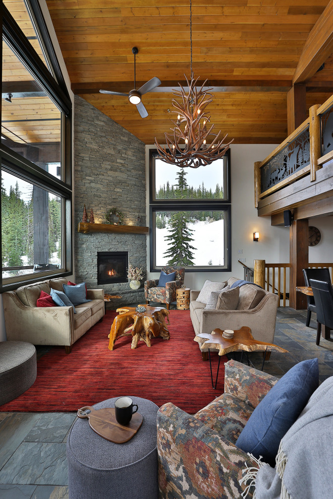 Photo of a country loft-style living room in Vancouver with white walls, slate floors, a corner fireplace, a wall-mounted tv, grey floor and wood.