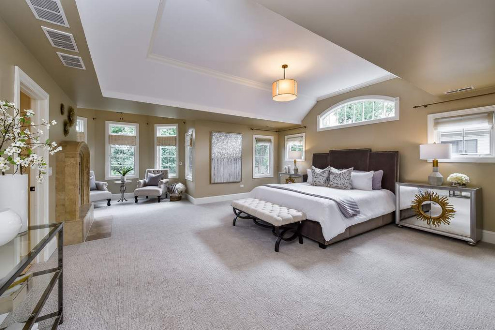 Design ideas for a large transitional master bedroom in Chicago with beige walls, carpet, a standard fireplace, a tile fireplace surround, vaulted and white floor.