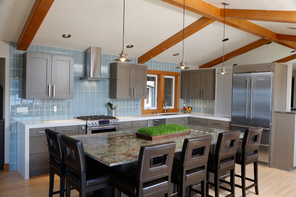 Inspiration for a mid-sized transitional l-shaped light wood floor kitchen remodel in Seattle with an undermount sink, shaker cabinets, gray cabinets, quartz countertops, blue backsplash, ceramic backsplash, stainless steel appliances and an island