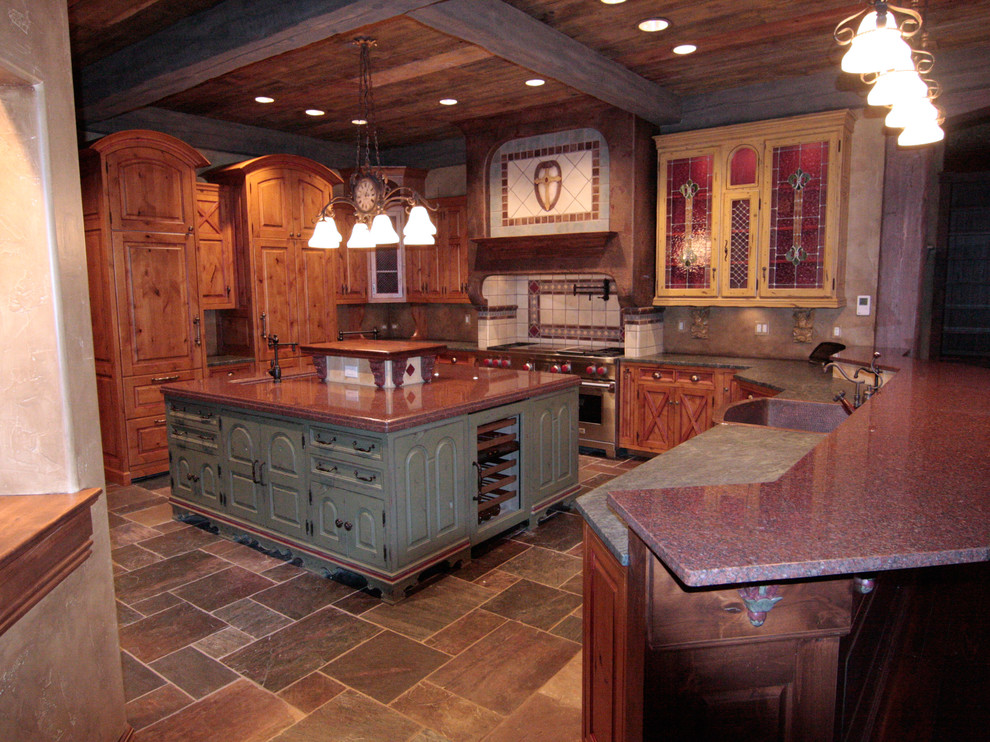 Inspiration for a large eclectic u-shaped slate floor eat-in kitchen remodel with a farmhouse sink, raised-panel cabinets, distressed cabinets, granite countertops, terra-cotta backsplash, paneled appliances and an island