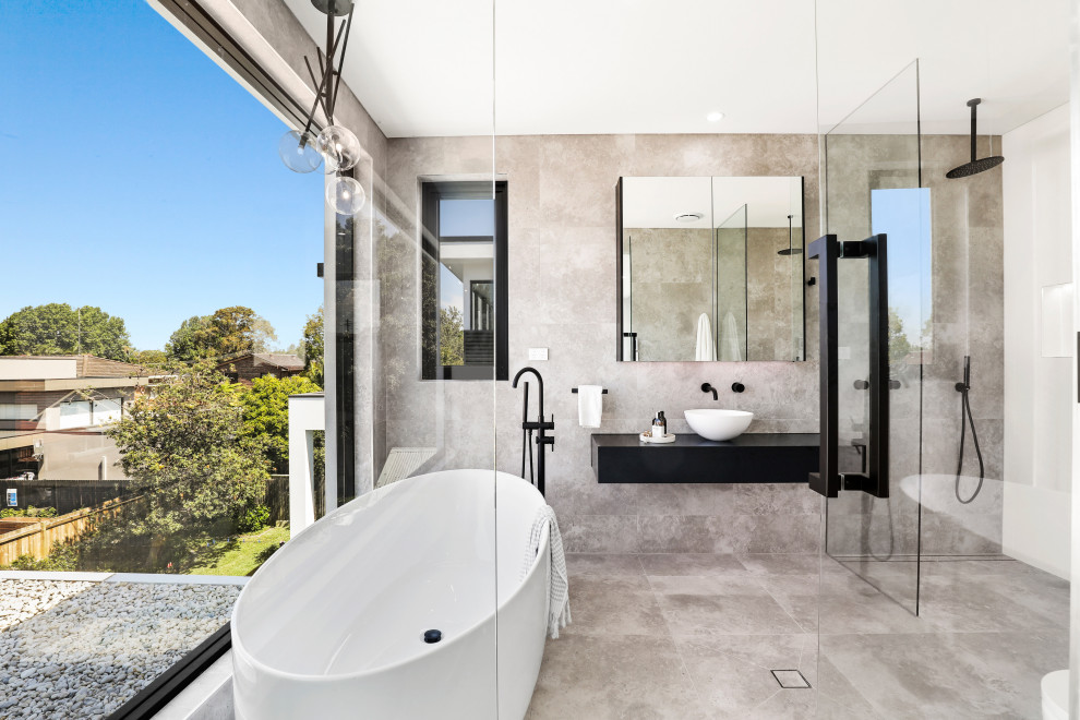 Design ideas for a contemporary bathroom in Sydney with flat-panel cabinets, black cabinets, a freestanding tub, gray tile, a vessel sink, grey floor, black benchtops, a single vanity and a floating vanity.