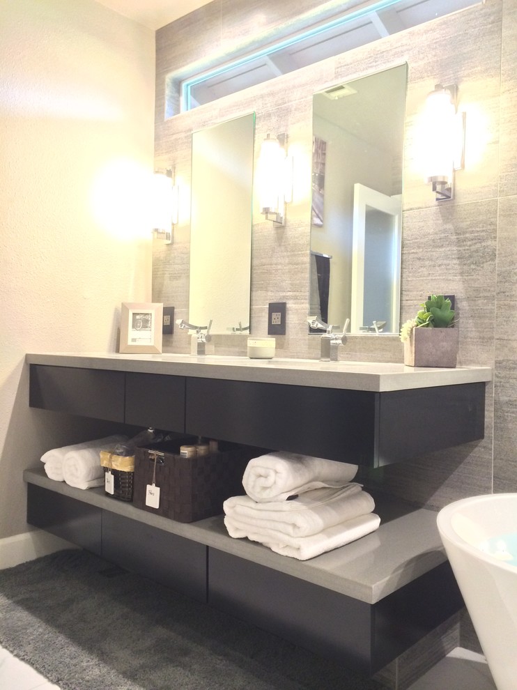 Inspiration for a mid-sized modern master gray tile and porcelain tile porcelain tile freestanding bathtub remodel in San Diego with an undermount sink, black cabinets, quartz countertops, gray walls, flat-panel cabinets and a two-piece toilet