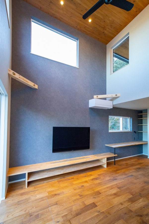 Ispirazione per un soggiorno con pareti grigie, pavimento in legno massello medio, TV a parete, pavimento marrone, soffitto in legno e carta da parati