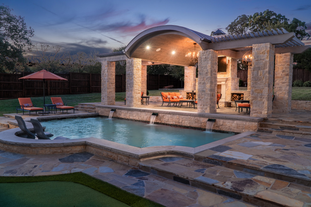 Photo of a large backyard patio in Dallas with with fireplace, natural stone pavers and a gazebo/cabana.
