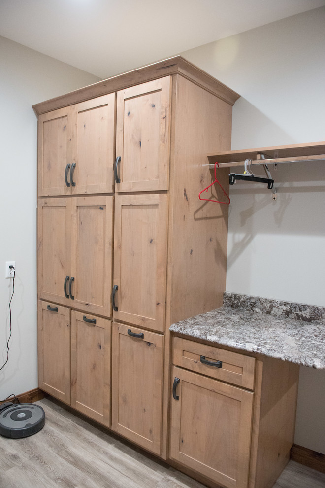 Photo of a large country u-shaped utility room in Other with an undermount sink, shaker cabinets, light wood cabinets, granite benchtops, white walls, laminate floors, a side-by-side washer and dryer and multi-coloured benchtop.
