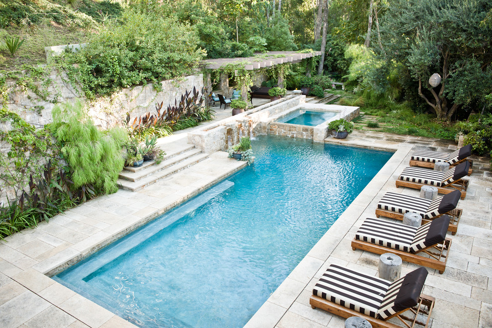 Mediterranean l-shaped pool in Los Angeles with natural stone pavers.