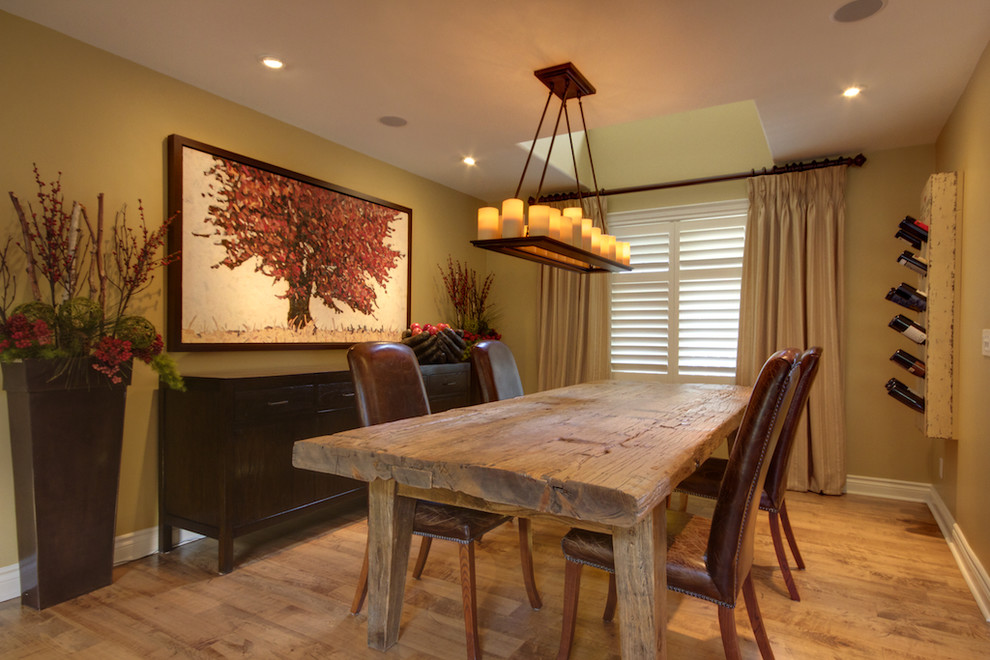 Country dining room in Toronto with green walls and medium hardwood floors.