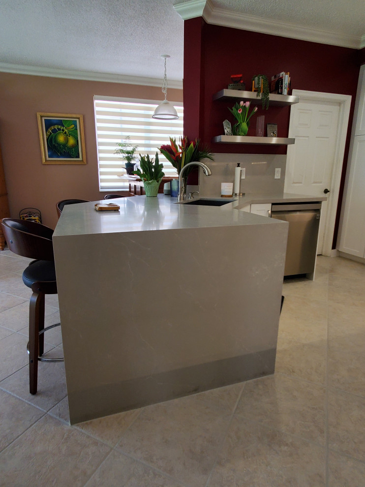 Exemple d'une petite arrière-cuisine chic en U avec un placard à porte shaker, des portes de placard blanches, un plan de travail en quartz modifié et une crédence en quartz modifié.