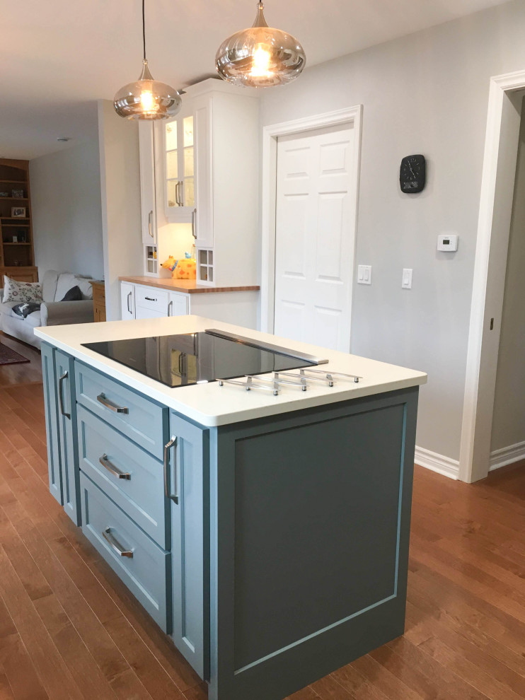 Enclosed kitchen - mid-sized transitional l-shaped medium tone wood floor and brown floor enclosed kitchen idea with a double-bowl sink, shaker cabinets, gray cabinets, quartz countertops, white backsplash, porcelain backsplash, stainless steel appliances, an island and white countertops