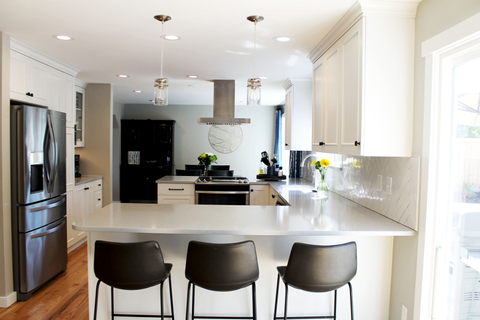 Mid-sized transitional u-shaped medium tone wood floor eat-in kitchen photo in Seattle with an undermount sink, shaker cabinets, white cabinets, quartz countertops, white backsplash, ceramic backsplash, stainless steel appliances, a peninsula and gray countertops