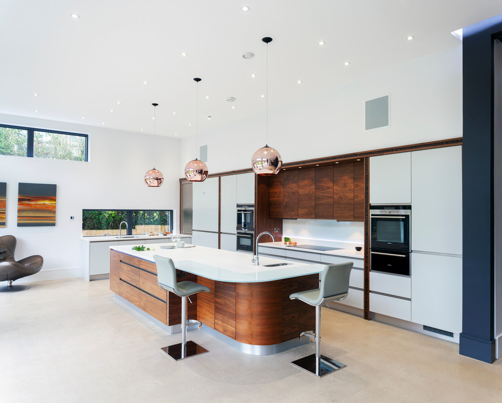 Large contemporary l-shaped kitchen in Other with an integrated sink, flat-panel cabinets, white cabinets, white splashback, stainless steel appliances and with island.