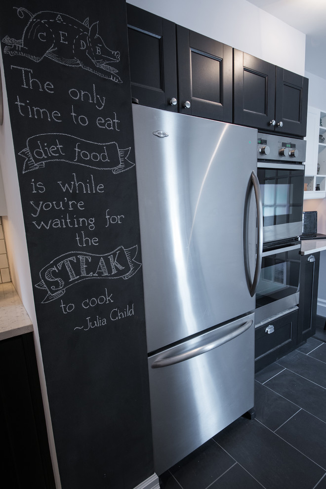 Example of a transitional galley home design design in Ottawa with recessed-panel cabinets, black cabinets, quartzite countertops, white backsplash, stainless steel appliances and no island