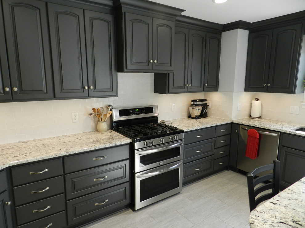Mid-sized transitional l-shaped separate kitchen in Cleveland with an undermount sink, raised-panel cabinets, grey cabinets, granite benchtops, white splashback, subway tile splashback, stainless steel appliances, porcelain floors, with island and beige floor.