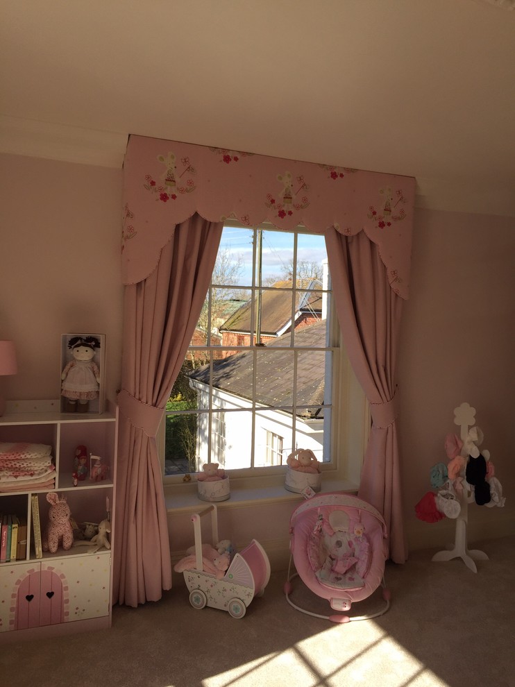 Photo of a traditional nursery for girls in Other with pink walls and carpet.