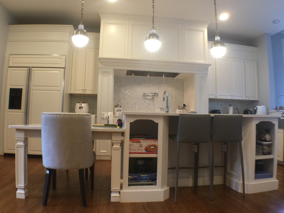 Example of a large transitional u-shaped medium tone wood floor open concept kitchen design in DC Metro with an undermount sink, raised-panel cabinets, white cabinets, quartzite countertops, stainless steel appliances and an island