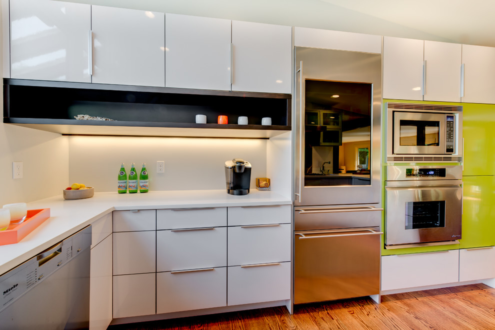 Kitchen pantry - mid-sized contemporary u-shaped medium tone wood floor kitchen pantry idea in Seattle with an undermount sink, flat-panel cabinets, white cabinets, quartz countertops, white backsplash, stainless steel appliances and no island