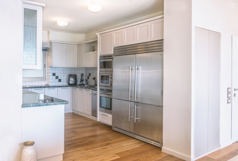 Photo of a mid-sized contemporary u-shaped separate kitchen in Other with louvered cabinets, white cabinets, granite benchtops, multi-coloured splashback, ceramic splashback, stainless steel appliances, painted wood floors and no island.