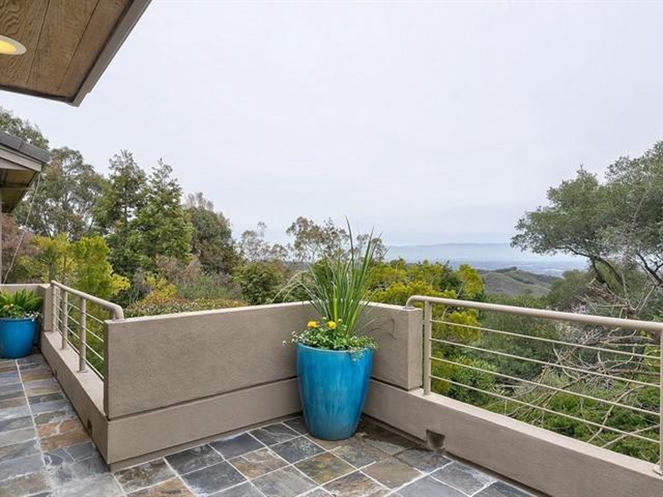 Photo of a large contemporary balcony in San Francisco with a roof extension and metal railing.