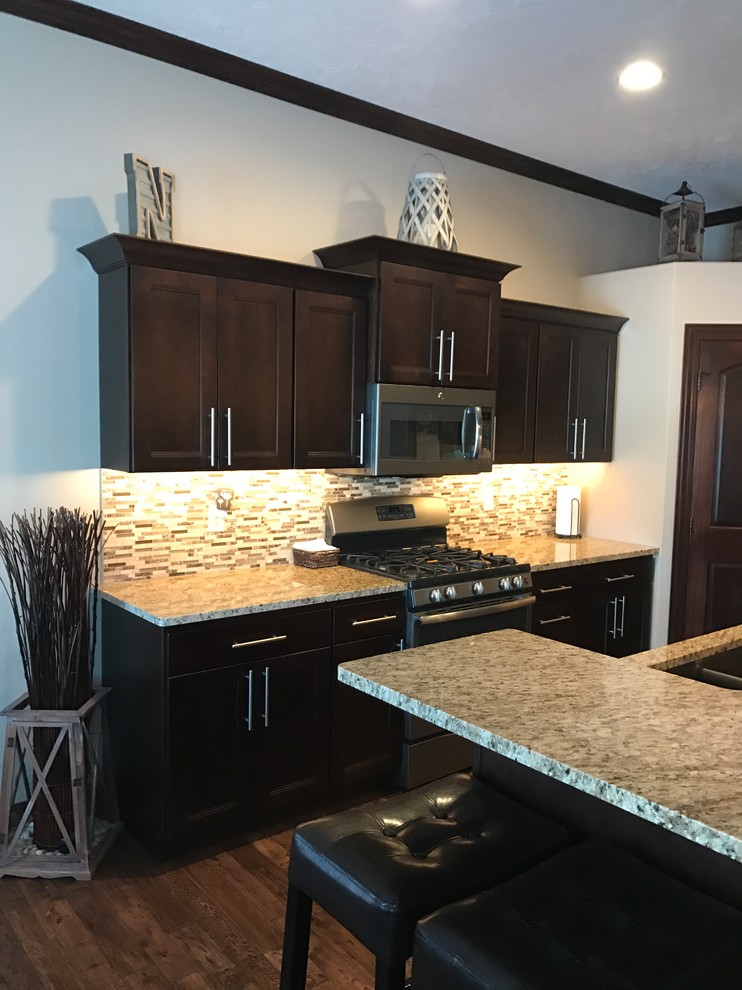 Kitchen - transitional l-shaped kitchen idea with an undermount sink, flat-panel cabinets, dark wood cabinets, granite countertops, multicolored backsplash, ceramic backsplash, stainless steel appliances and an island