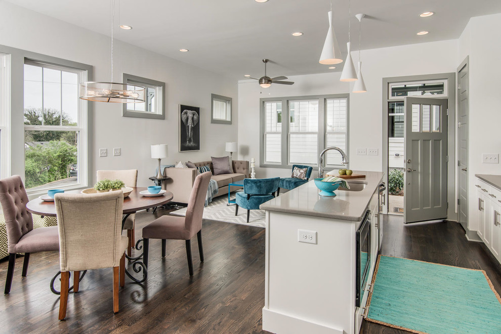 Small contemporary single-wall open plan kitchen in Nashville with an undermount sink, recessed-panel cabinets, white cabinets, quartz benchtops, stainless steel appliances, dark hardwood floors and with island.
