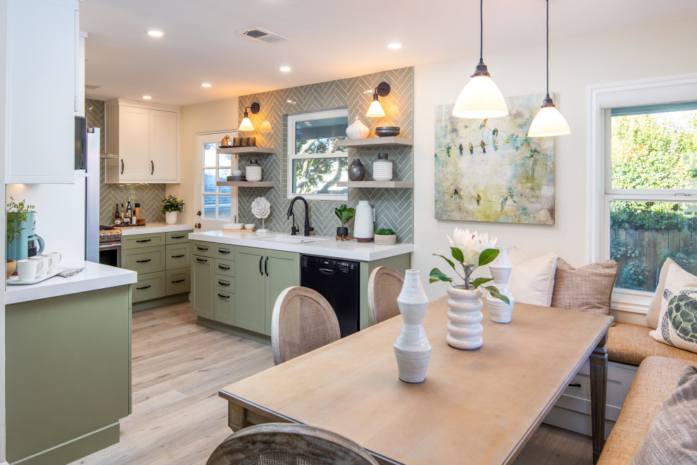 Photo of a mid-sized transitional u-shaped eat-in kitchen in San Diego with an undermount sink, shaker cabinets, green cabinets, quartz benchtops, green splashback, ceramic splashback, stainless steel appliances, vinyl floors, no island, grey floor and white benchtop.