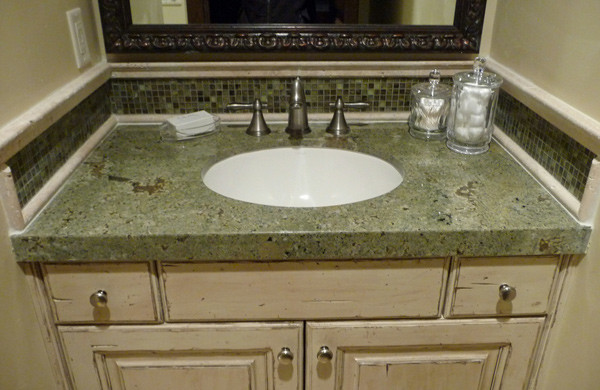 Photo of a small traditional bathroom in Salt Lake City with an undermount sink, distressed cabinets, granite benchtops, green tile, beige walls, raised-panel cabinets, mosaic tile and green benchtops.