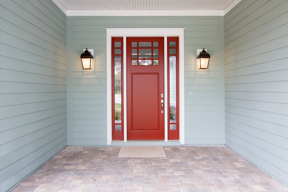 This is an example of a beach style front door in Jacksonville with a single front door and a red front door.