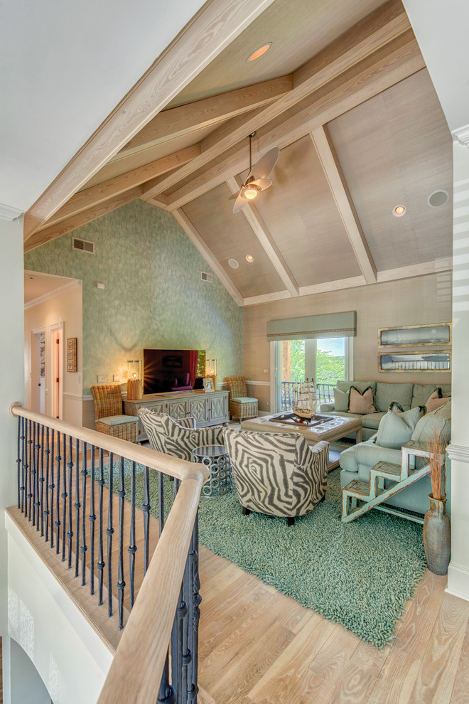 Photo of a mid-sized beach style loft-style family room in Charlotte with light hardwood floors, a freestanding tv and green walls.
