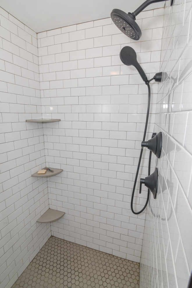 Пример оригинального дизайна: ванная комната среднего размера в стиле кантри с плоскими фасадами, коричневыми фасадами, душем в нише, унитазом-моноблоком, белой плиткой, плиткой кабанчик, бежевыми стенами, полом из цементной плитки, врезной раковиной, столешницей из искусственного кварца, бежевым полом, душем с распашными дверями, бежевой столешницей, тумбой под одну раковину и подвесной тумбой