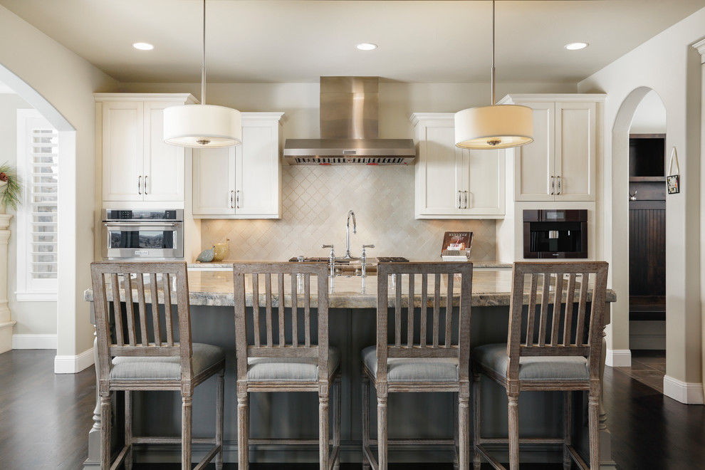 Example of a transitional dark wood floor kitchen design in Denver with shaker cabinets, beige cabinets, beige backsplash, stainless steel appliances and an island
