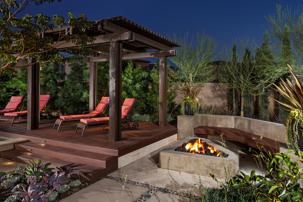 Design ideas for a mediterranean backyard deck in Orange County with a fire feature and a pergola.