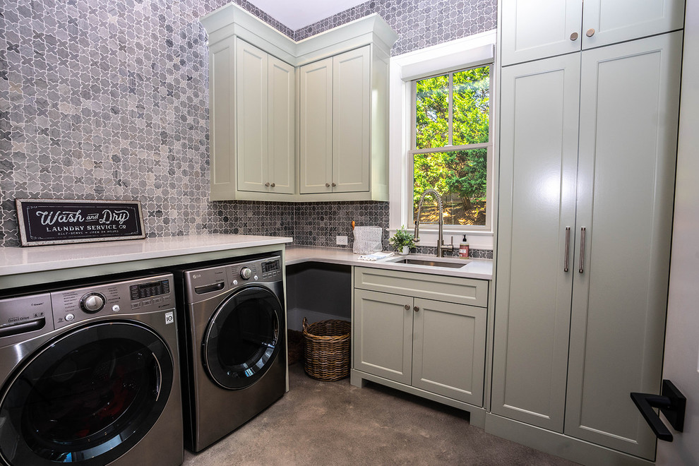 This is an example of a mid-sized contemporary l-shaped dedicated laundry room in Atlanta with an undermount sink, shaker cabinets, grey cabinets, solid surface benchtops, concrete floors, a side-by-side washer and dryer and white benchtop.
