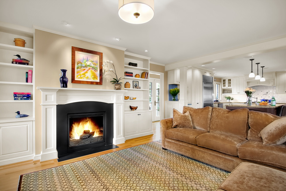 Traditional family room in Seattle with beige walls, light hardwood floors, a standard fireplace and no tv.
