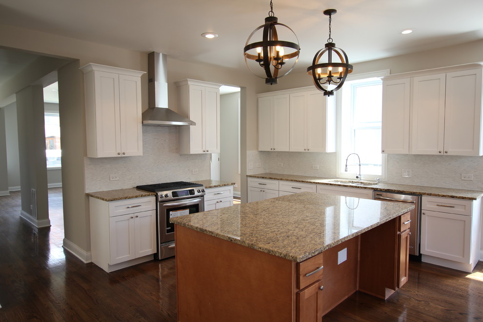 Open concept kitchen - large transitional u-shaped medium tone wood floor open concept kitchen idea in Chicago with an undermount sink, shaker cabinets, white cabinets, granite countertops, gray backsplash, stone tile backsplash, stainless steel appliances, gray walls and an island