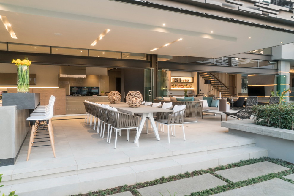 Inspiration for a contemporary patio kitchen remodel with a roof extension