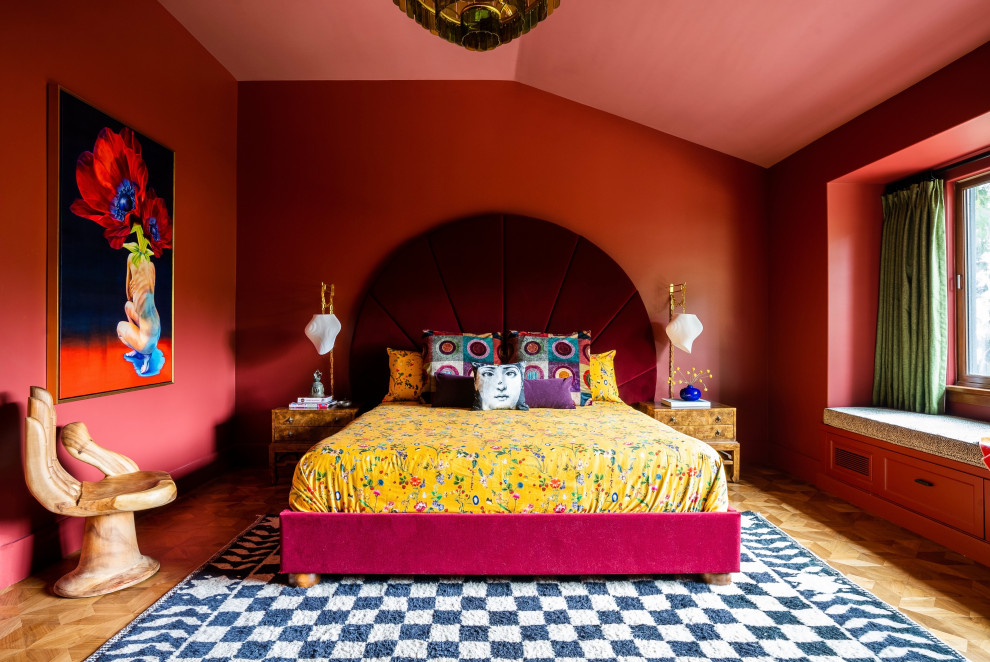 Imagen de dormitorio principal y abovedado ecléctico con paredes rojas y suelo de madera en tonos medios