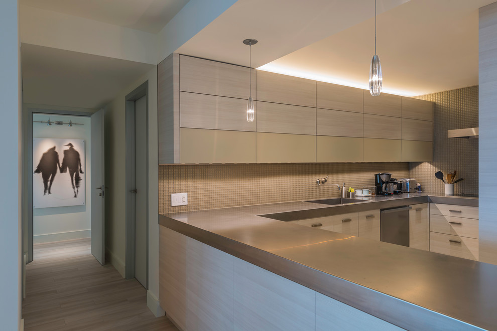 Contemporary u-shaped kitchen in Chicago with flat-panel cabinets, light wood cabinets, beige splashback and mosaic tile splashback.