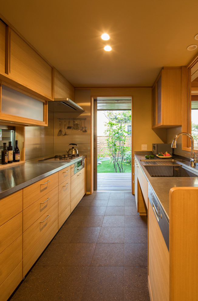 This is an example of an asian kitchen in Other with a single-bowl sink, flat-panel cabinets, medium wood cabinets, stainless steel benchtops, a peninsula, brown floor and brown benchtop.