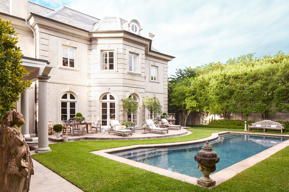 Inspiration for a large traditional backyard custom-shaped lap pool in New Orleans with concrete pavers.