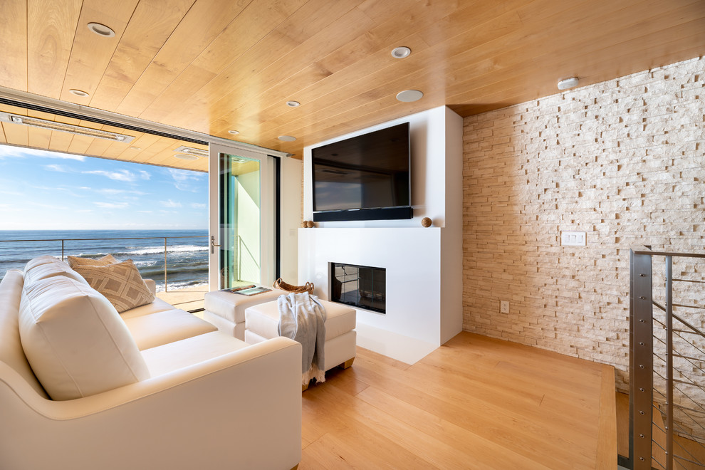 Inspiration for a huge contemporary open concept light wood floor and yellow floor living room remodel in Los Angeles with white walls, a standard fireplace, a stone fireplace and a wall-mounted tv