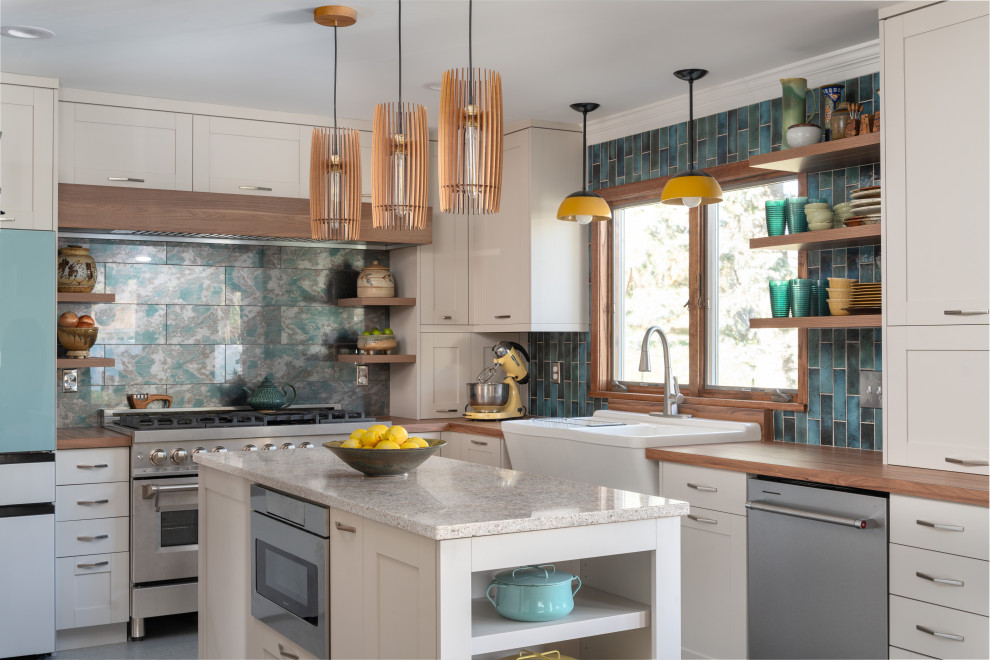 Design ideas for a mid-sized midcentury u-shaped open plan kitchen in Minneapolis with a farmhouse sink, shaker cabinets, white cabinets, laminate benchtops, blue splashback, glass tile splashback, coloured appliances, vinyl floors, with island, brown benchtop and green floor.