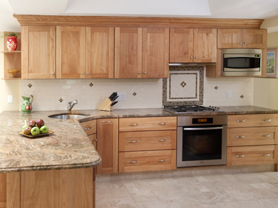 Kitchen photo in Boston with a single-bowl sink, recessed-panel cabinets, light wood cabinets, beige backsplash and stainless steel appliances