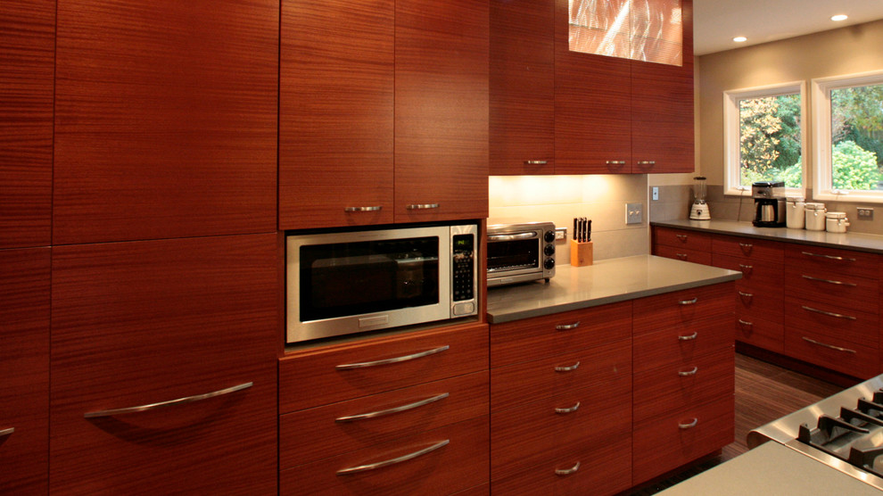 Contemporary kitchen in Portland with flat-panel cabinets, medium wood cabinets and stainless steel appliances.
