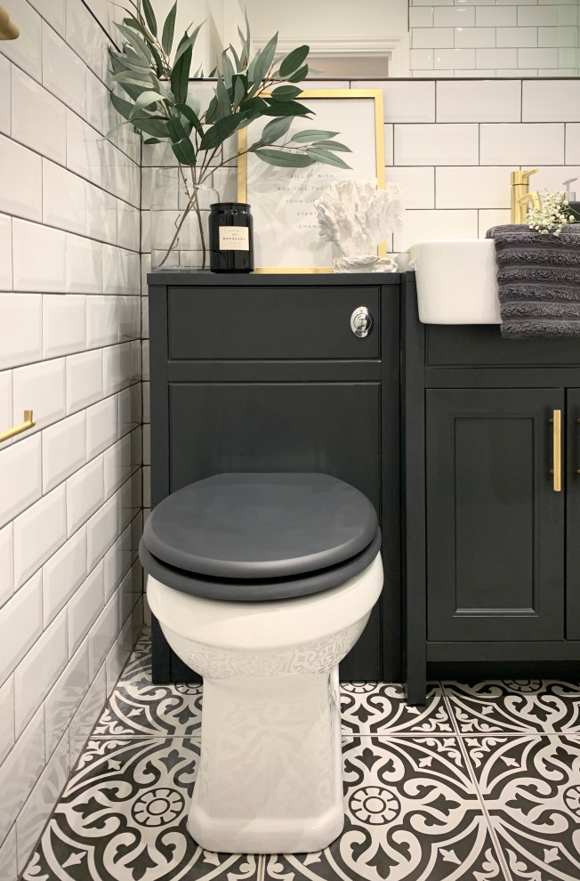 Medium sized traditional family bathroom in London with shaker cabinets, blue cabinets, a freestanding bath, a one-piece toilet, white tiles, ceramic tiles, white walls, porcelain flooring, multi-coloured floors, a single sink and a built in vanity unit.