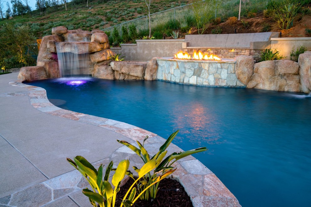 Inspiration for a large contemporary backyard custom-shaped lap pool in San Diego with a water slide and concrete pavers.