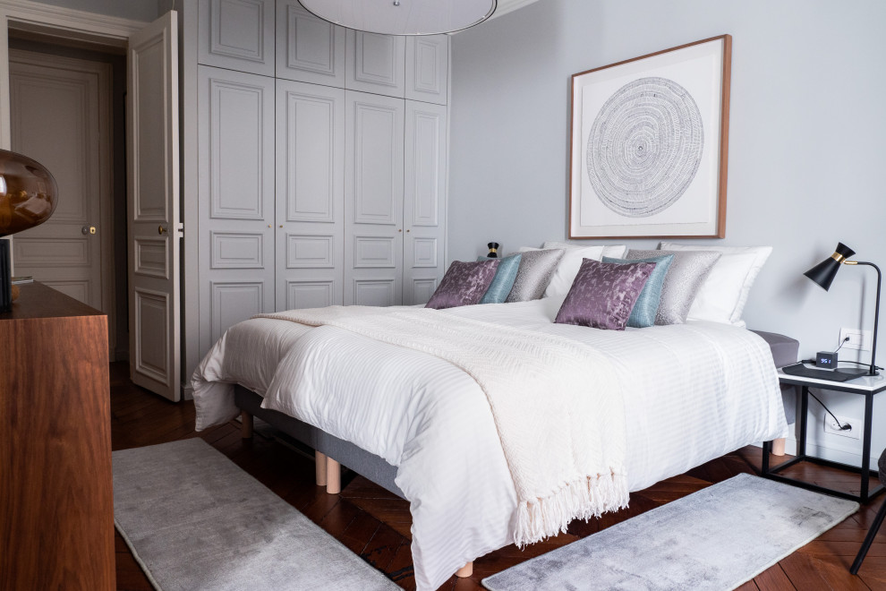 Mid-sized transitional master bedroom in Paris with grey walls and dark hardwood floors.