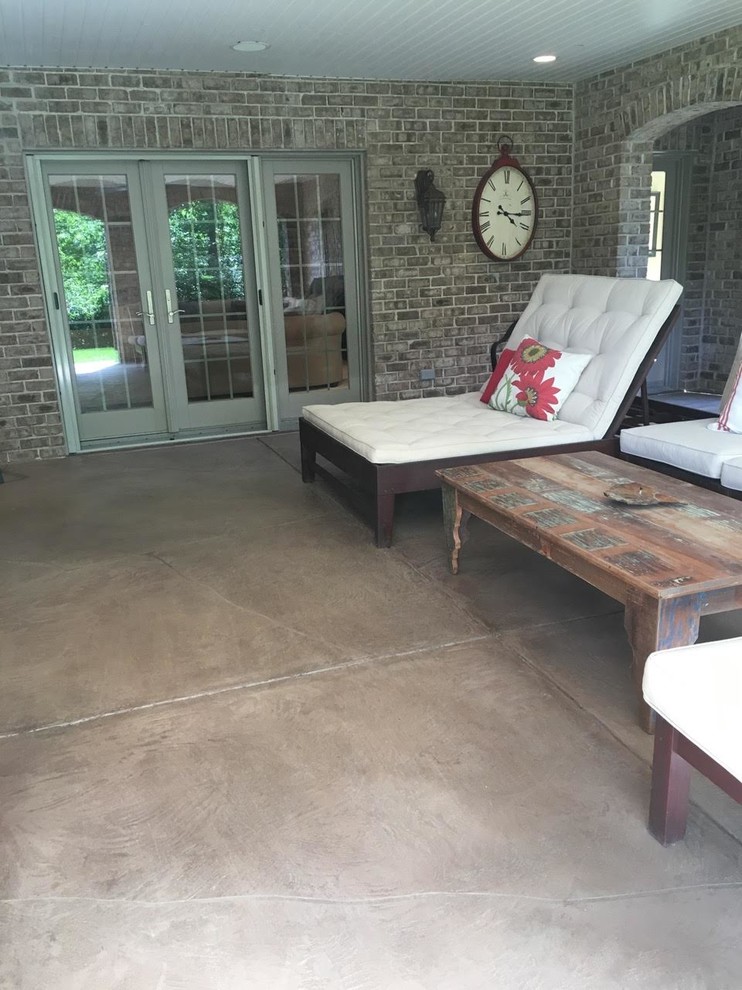 This is an example of a mid-sized traditional side yard patio in St Louis with stamped concrete and a roof extension.