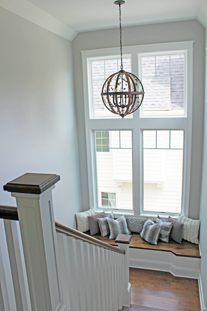 Example of a large transitional wooden u-shaped wood railing staircase design in Chicago with painted risers