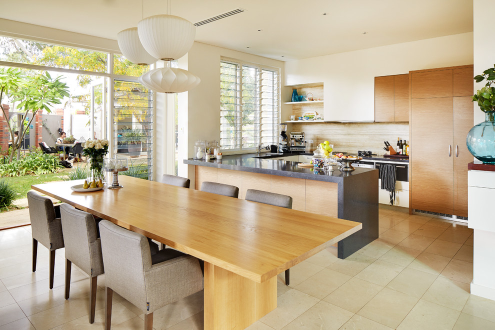 This is an example of a contemporary u-shaped eat-in kitchen in Perth with flat-panel cabinets, medium wood cabinets, beige splashback, panelled appliances, a peninsula, beige floor and grey benchtop.