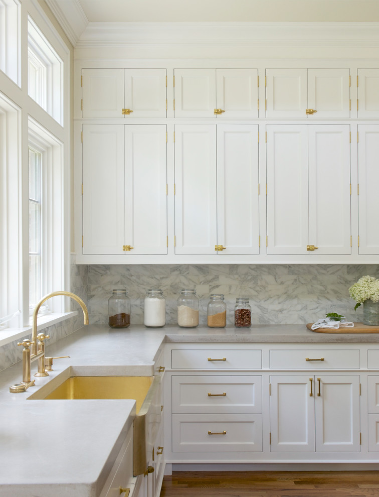 Inspiration for a transitional open plan kitchen in New York with a farmhouse sink, shaker cabinets, white cabinets, white splashback, medium hardwood floors, marble benchtops, with island and marble splashback.
